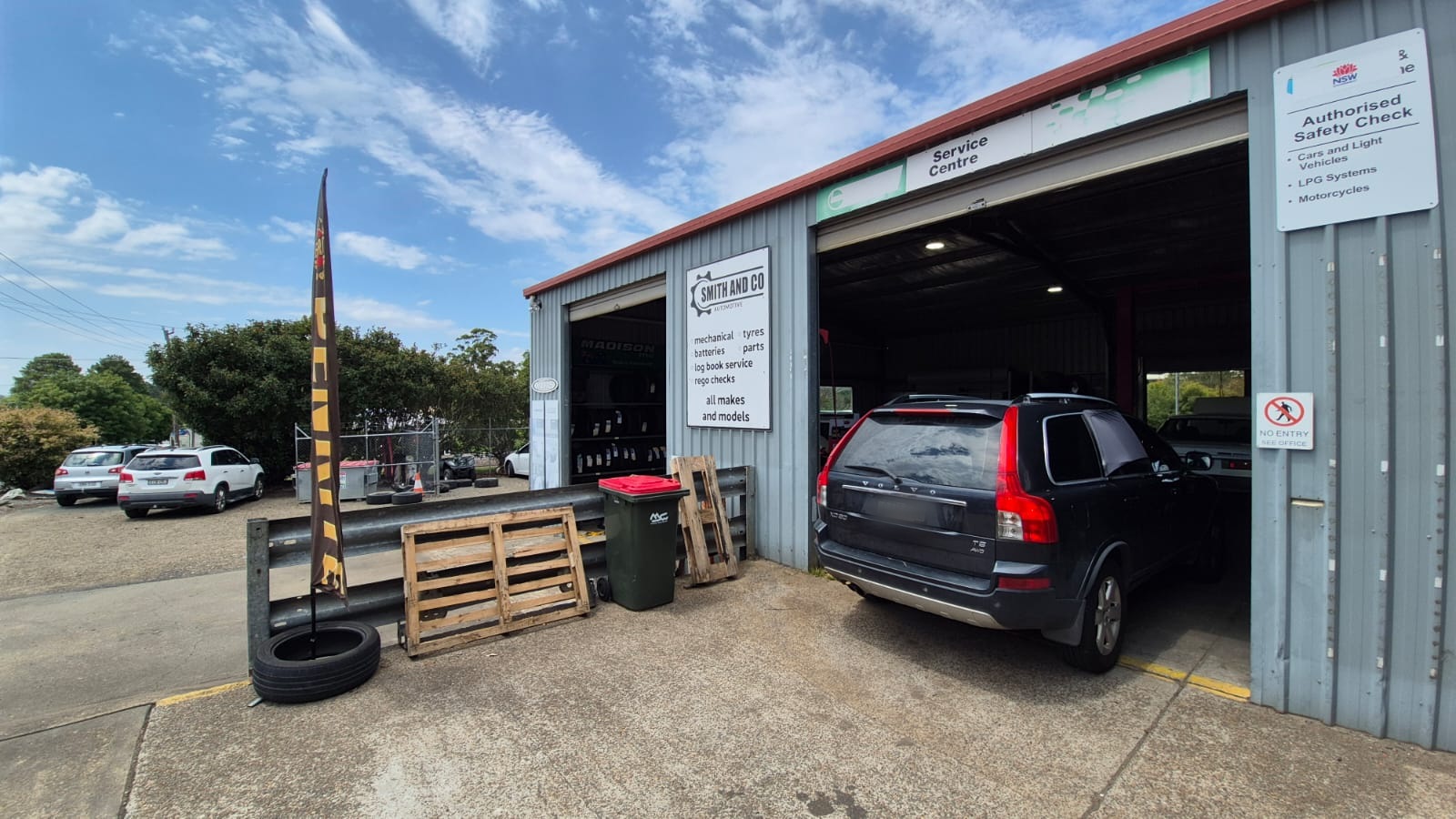 The service board and Authorised Safety Check sign at the entrance to the Smith & Co Automotive workshop